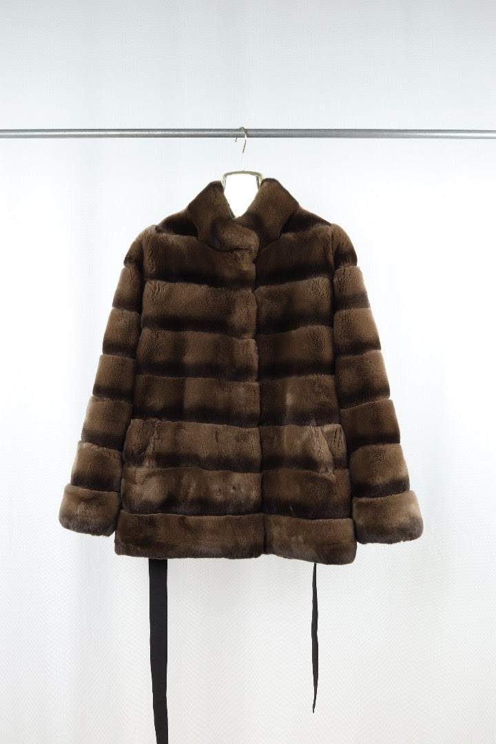 reversible Brown fur coat on a hanger against a white background